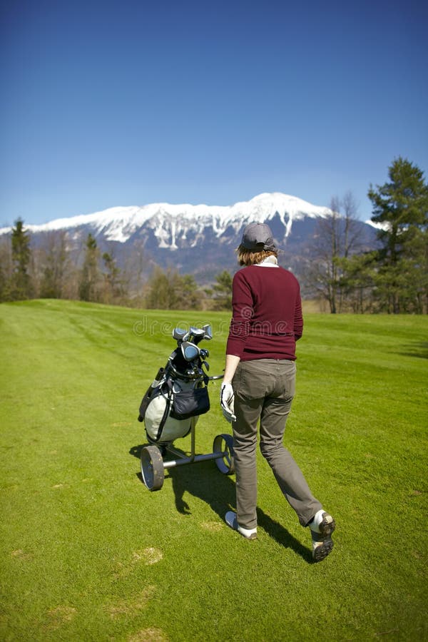 Woman pushing her golf bag trolley