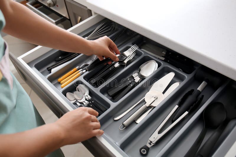 https://thumbs.dreamstime.com/b/woman-putting-fork-kitchen-drawer-151239708.jpg