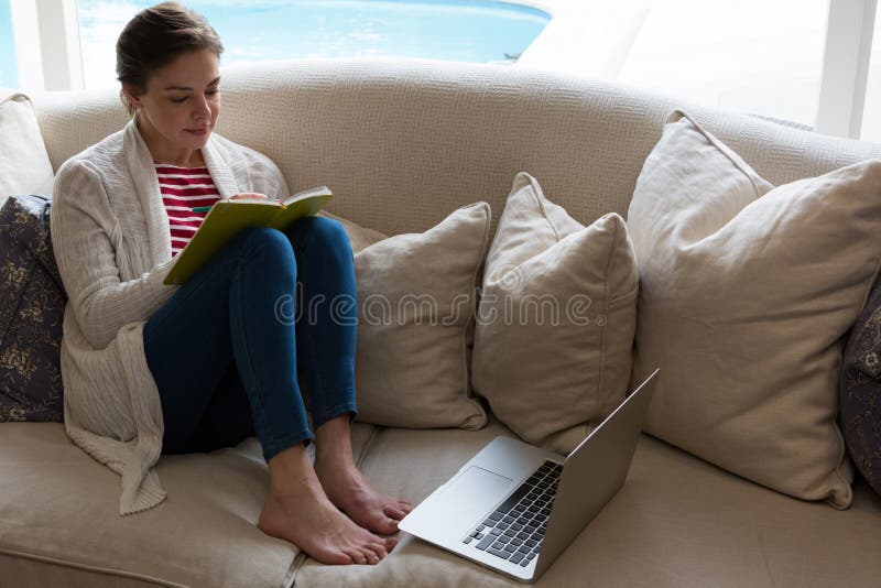 Woman reading book on sofa