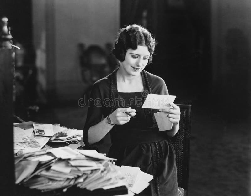 Woman reading letter with pile of mail stock photos Woman reading letter with pile of mail stock photos