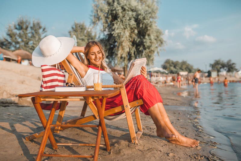 Woman reading newspaper on the beach