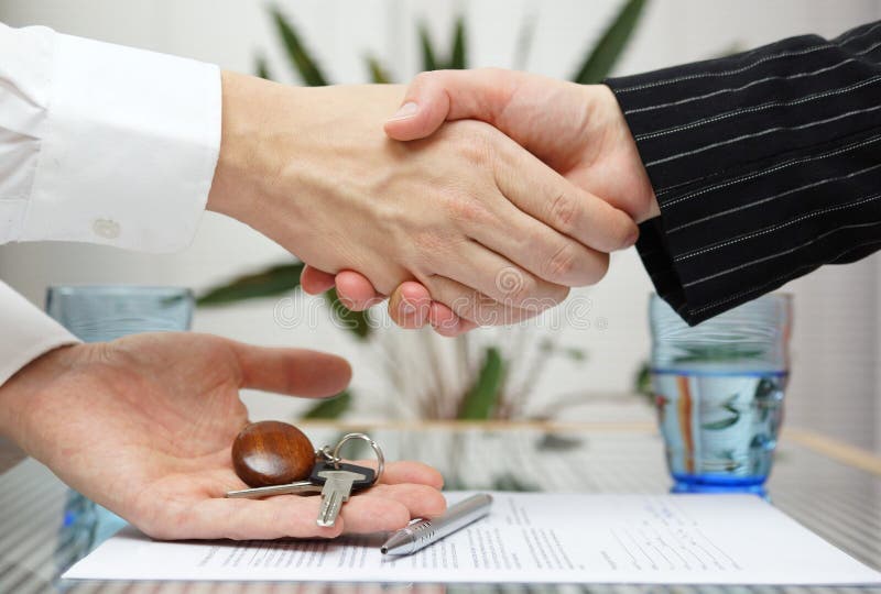 Woman receiving a handshake and a house key