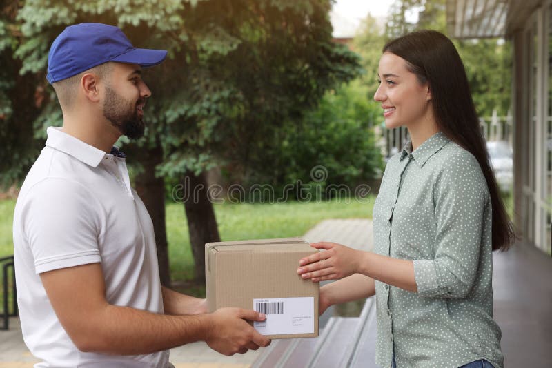 Woman Receiving Parcel from Courier Outdoors. Delivery Service Stock