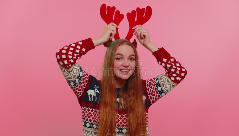 Young adult girl in Christmas deer antlers listening music, dancing disco fooling around having fun
