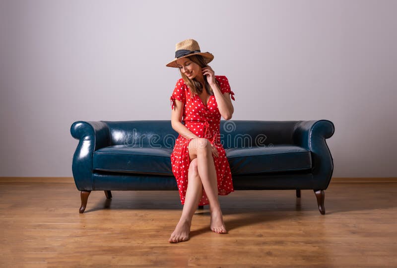 A Woman In A Red Dress Sitting On A Sofa Stock Image Image Of Beauty Elegant 179967277