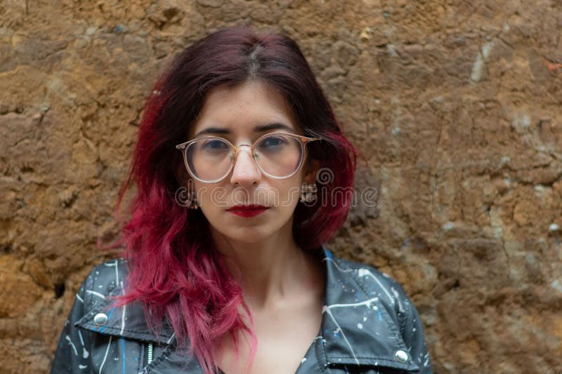 Woman with Red Dyed Hair in a Leather Jacket Against a Wall Stock Photo ...