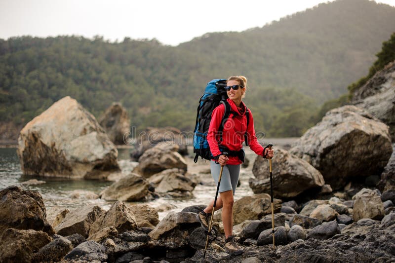 Woman with hiking equipment trekking through rocky coast royalty free stock image Woman with hiking equipment trekking through rocky coast royalty free stock image
