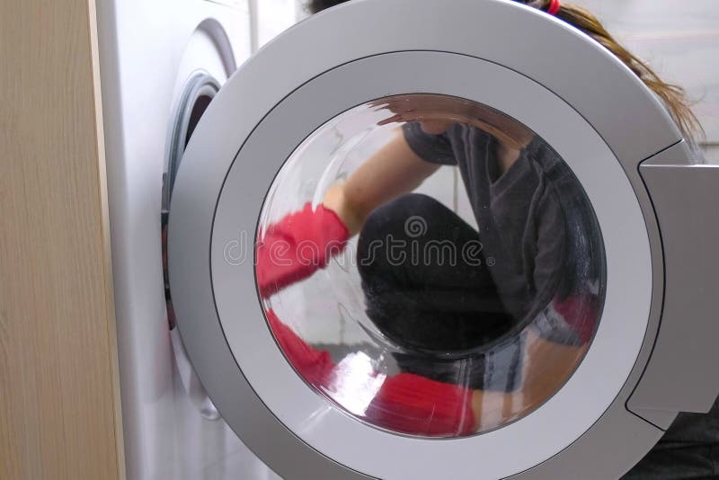 Woman in Red Rubber Gloves is Washing a Washing Machine with Sponge