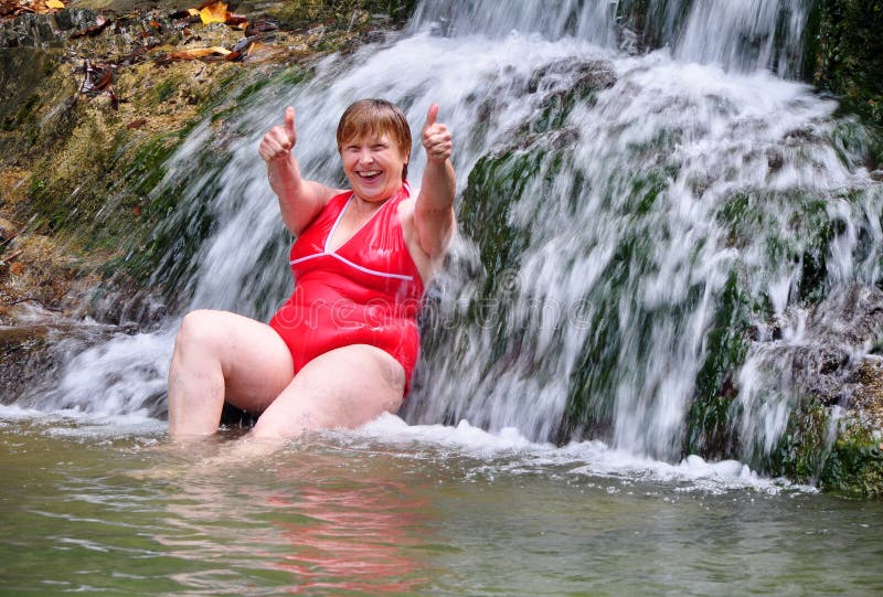 Woman in red swimsuit enjoying a waterfall