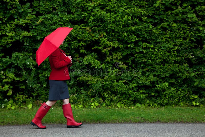 Woman in red walking with umbrella royalty free stock images Woman in red walking with umbrella royalty free stock images