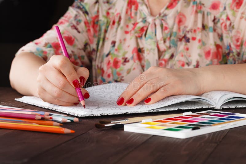 Woman relaxing while do painting adult coloring book