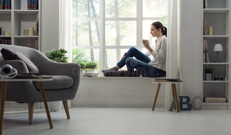 Woman relaxing at home and having coffee