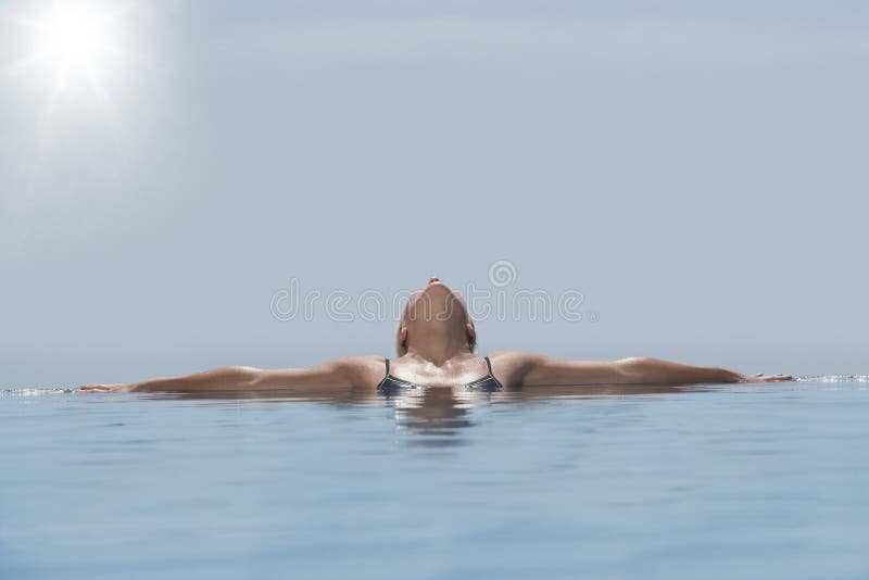 Woman Relaxing In Infinity Pool