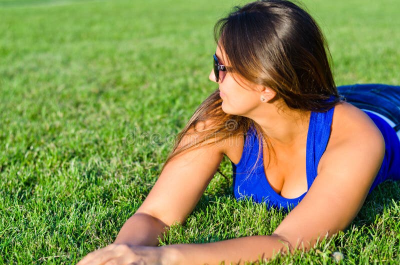 Woman relaxing lying on grass