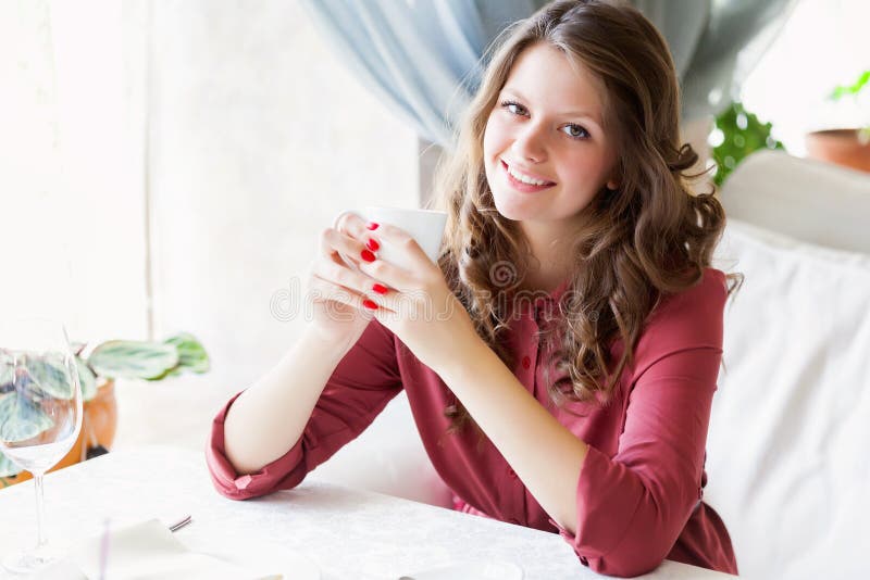 A woman in a restaurant is drinking coffee royalty free stock photos