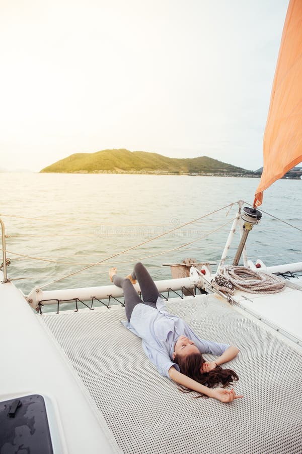 Woman Resting On Ship Deck While Enjoying A Cruise On A Boat Stock