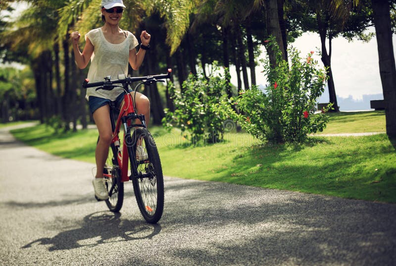 woman ride bike in sunny tropical park