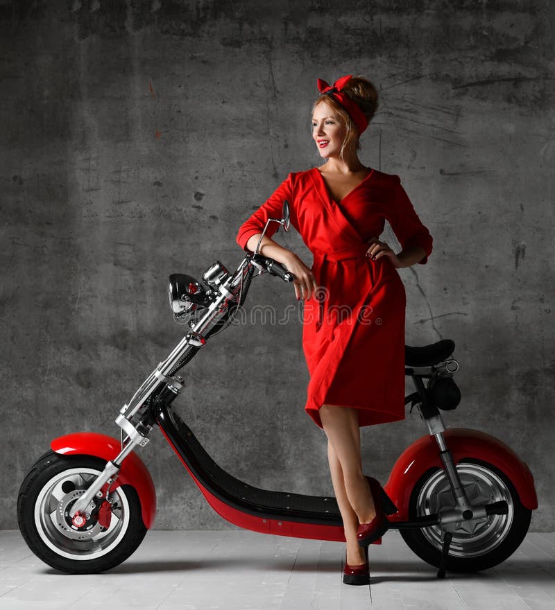 Woman ride sit on motorcycle bicycle scooter pinup retro style laughing smiling red dress royalty free stock photo Woman ride sit on motorcycle bicycle scooter pinup retro style laughing smiling red dress royalty free stock photo