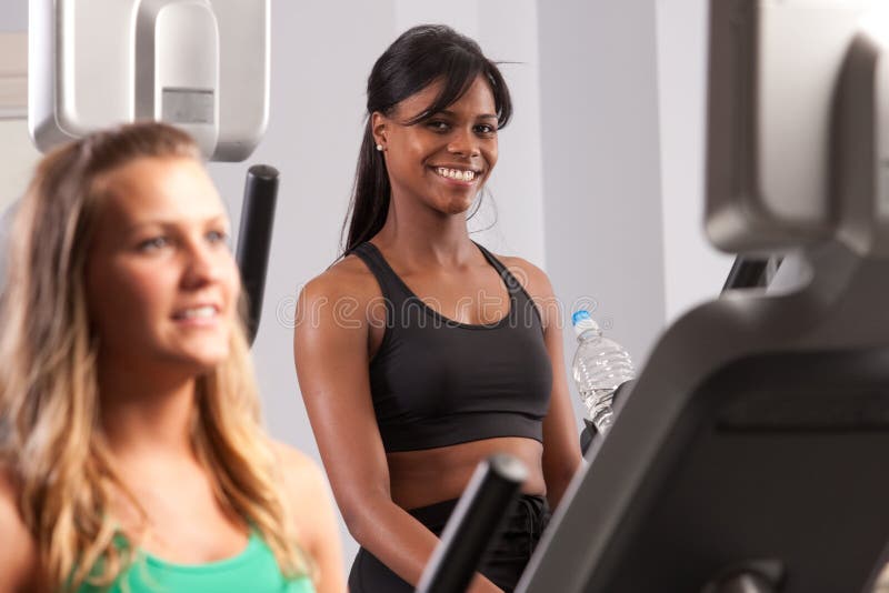 Woman riding exercise bike stock images