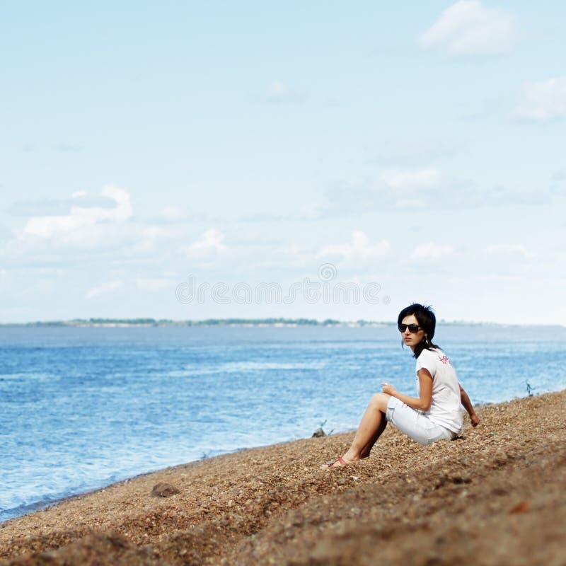 Woman on riverbank stock photo. Image of shore, seated - 10366170