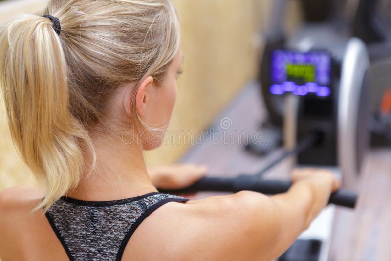 Woman on rowing machine stock photography