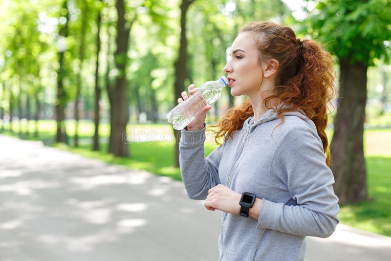 Woman runner is having break, drinking water