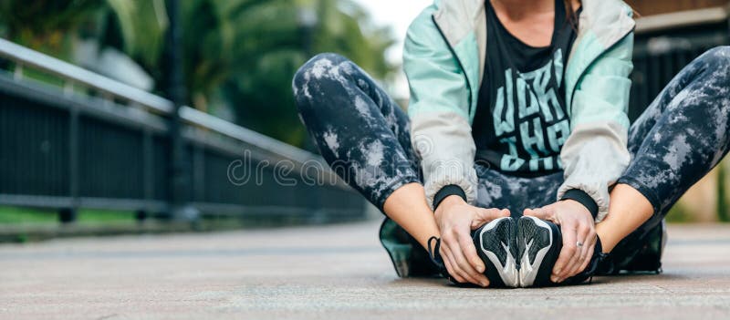 Woman runner relaxing sitting on the floor after training