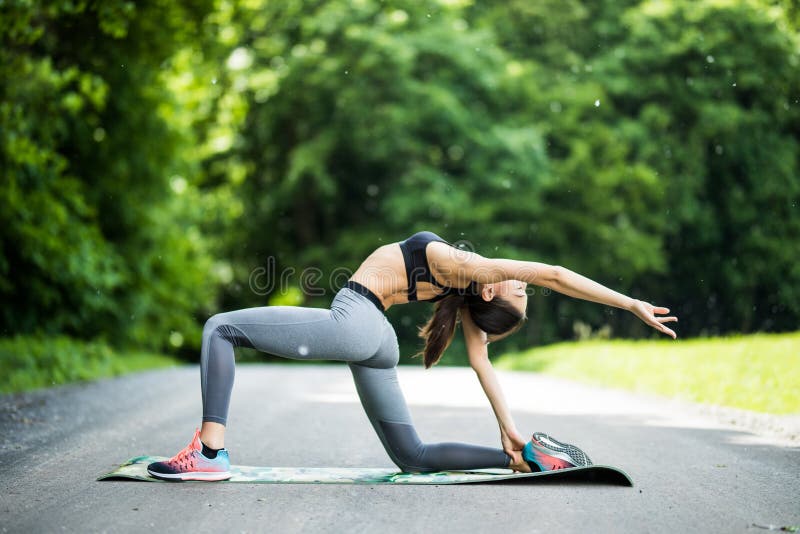 Woman runner stretching legs before run. Beautiful smiling young stock images Woman runner stretching legs before run. Beautiful smiling young stock images