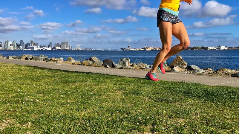 Woman Running Along Urban Waterfront, San Diego, California, USA Stock