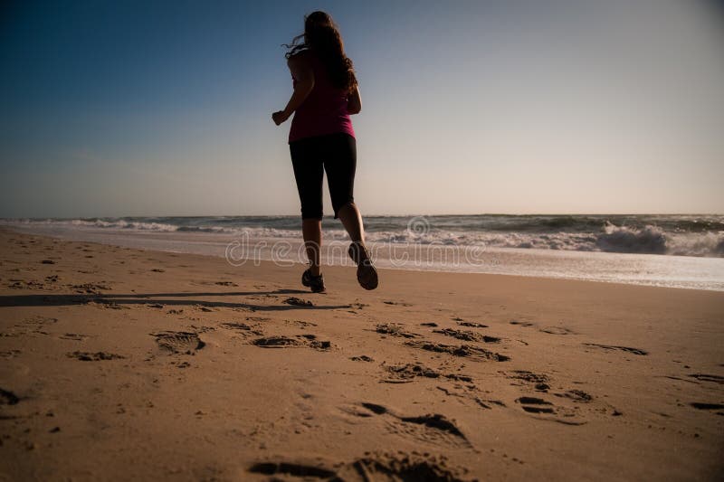Woman running on the beach stock photo. Image of attractive 16628728