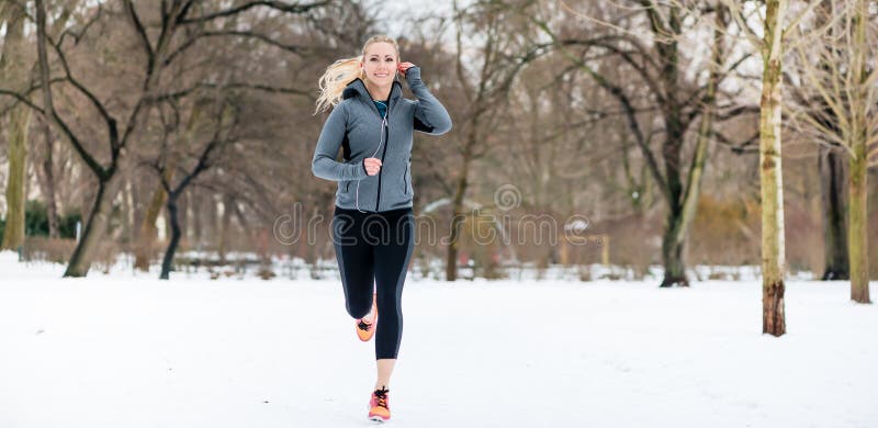 Woman running down a path on winter day in park