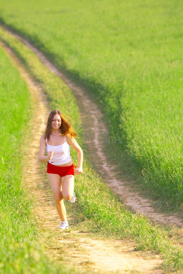 Woman running in the fields stock photos