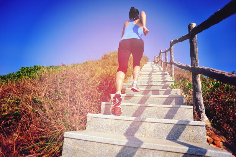 Woman running up on mountain stairs