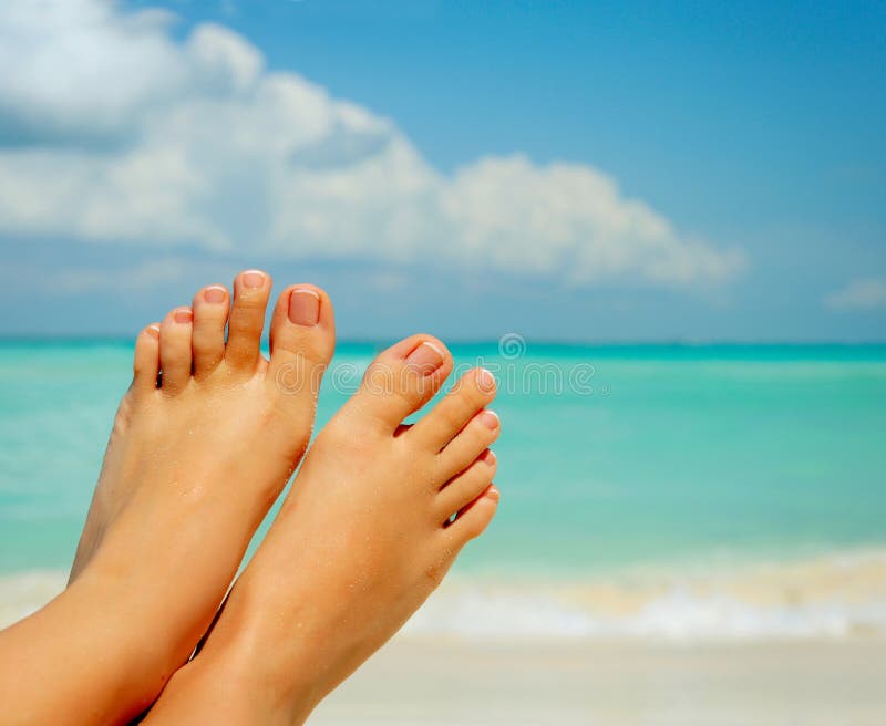 Womans Bare Feet over Sea background