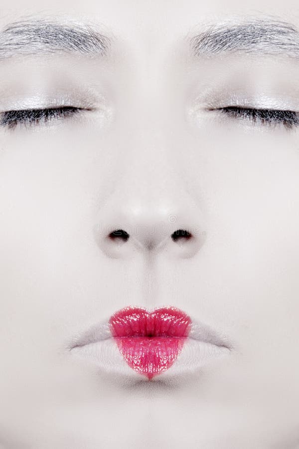 Il womans faccia close-up, con le labbra dipinte a forma di cuore rossetto rosso.