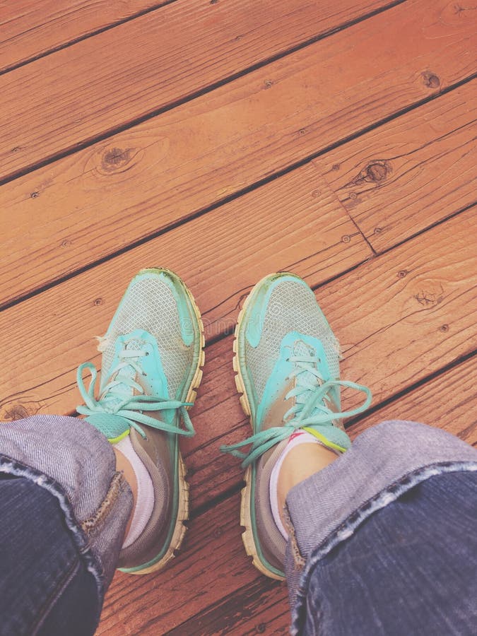 Woman& X27;s Feet in Sneakers, Resting on a Wood Deck Stock Photo ...