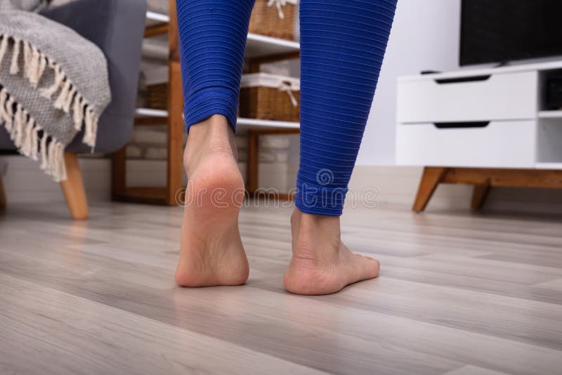 Woman`s Feet Walking On Hardwood Floor