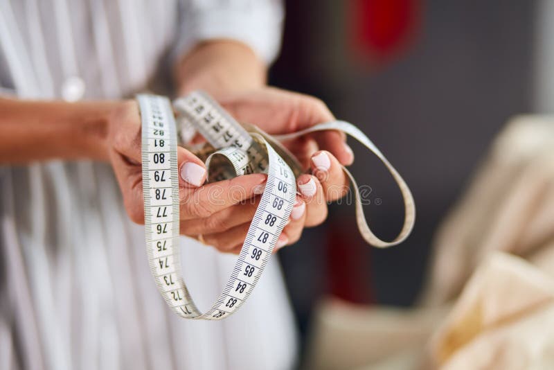 Woman`s hand holding tailor measuring tape stock images Woman`s hand holding tailor measuring tape stock images