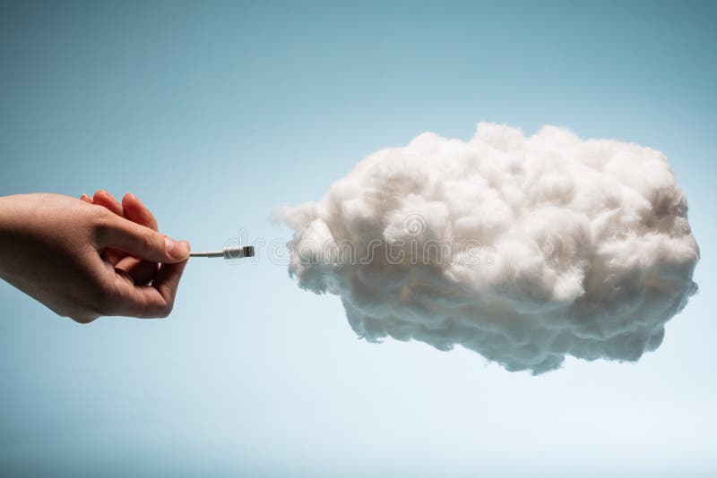 Woman`s hand plugging a wire into a white cloud.