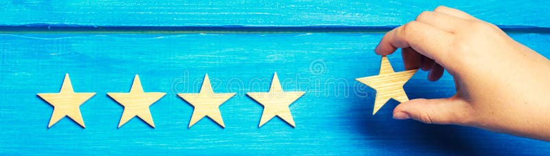 A woman`s hand puts the fifth star. Quality status is five stars. A new star, achievement, universal recognition.The critic determines the rating of the restaurant, hotel, institution. Quality mark. banner.