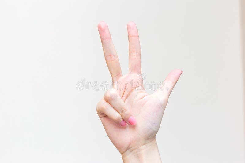 Womanâ€™s hand shows up three fingers as number three on white background