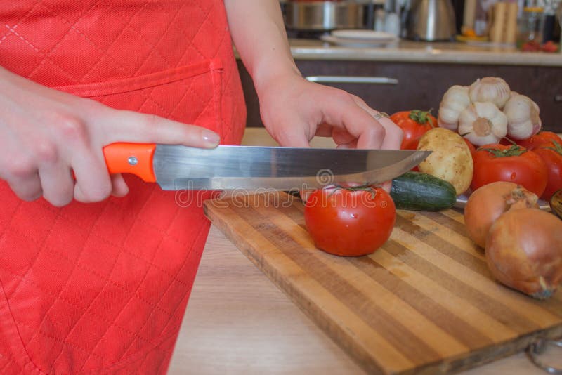 Woman`s hands cutting vegetables, behind fresh vegetables. Woman cook at the kitchen royalty free stock photo Woman`s hands cutting vegetables, behind fresh vegetables. Woman cook at the kitchen royalty free stock photo