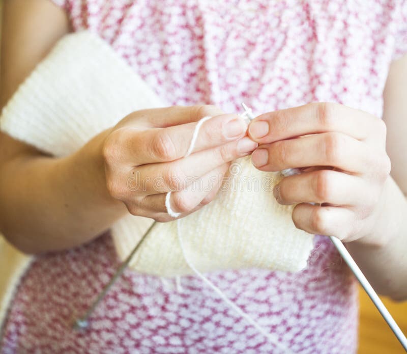 Woman s hands knitting a white scarf