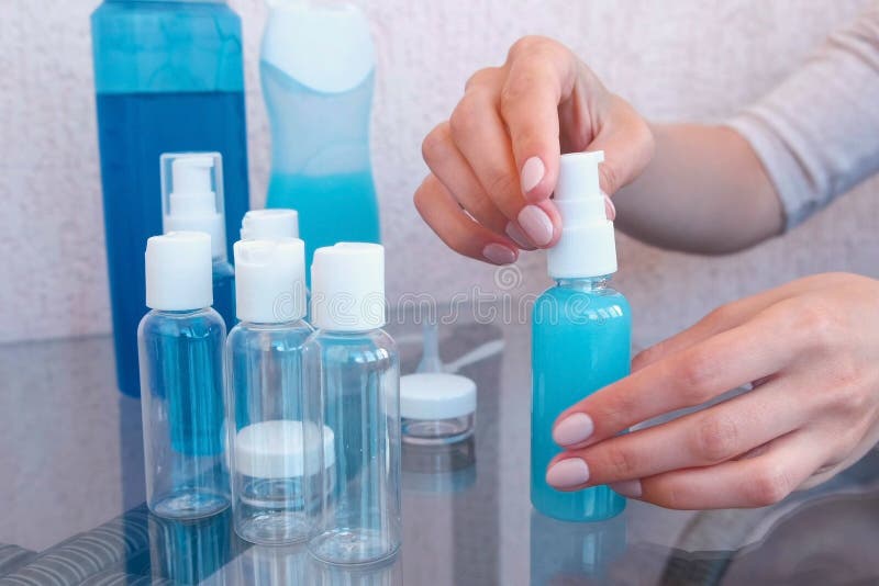 Woman`s hands twist cap on a small bottle of shower gel. Travel set of jars. Woman`s hands twist cap on a small bottle of shower gel. Travel set of jars royalty free stock photography Woman`s hands twist cap on a small bottle of shower gel. Travel set of jars. Woman`s hands twist cap on a small bottle of shower gel. Travel set of jars royalty free stock photography