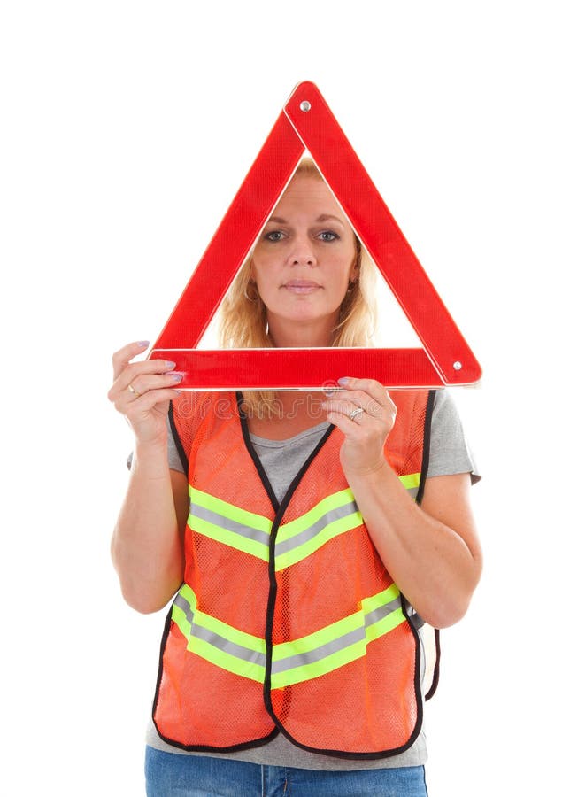 Woman in safety vest holding foldaway reflective road hazard warning triangle over white background