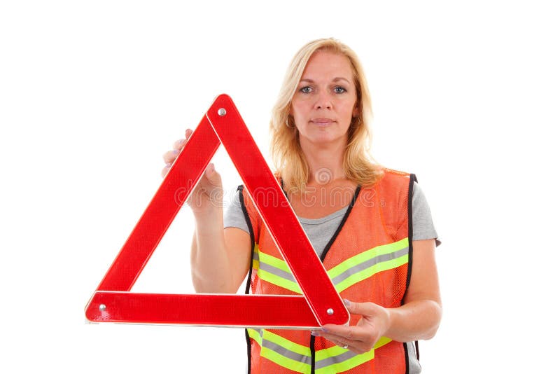 Woman in safety vest holding foldaway reflective road hazard warning triangle over white background