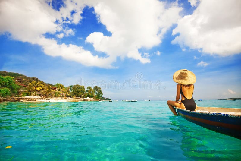 Woman sailing a boat in a paradise island