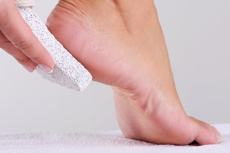 Woman scrubbing foot by pumice royalty free stock photo
