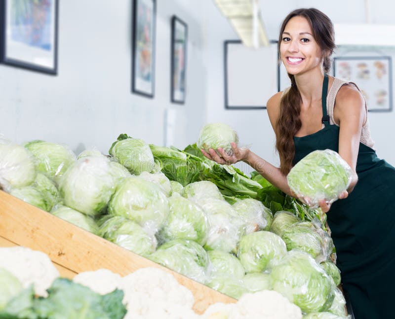 Woman seller wearing apron picking fresh cabbage head royalty free stock photos Woman seller wearing apron picking fresh cabbage head royalty free stock photos