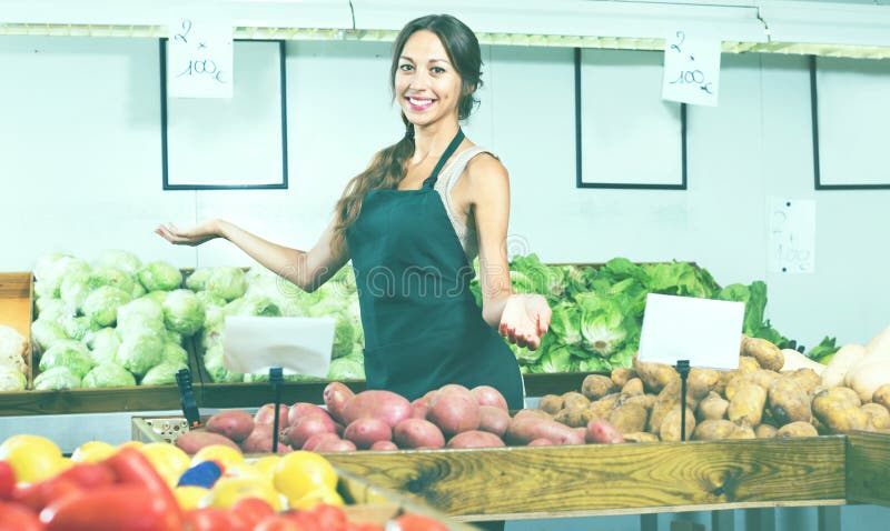 Woman seller wearing apron showing potatoes stock images Woman seller wearing apron showing potatoes stock images
